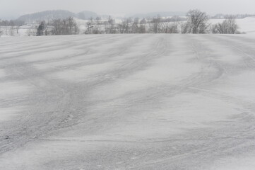 Fototapeta premium A snowy black and white and grey rural landscape with fields covered with snow in winter in Hokkaido, northern Japan, Asia