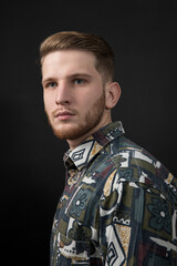 Obraz premium Handsome man in shirt - posing at studio. Attractive guy with fashion hairstyle. Adult boy with brown hair, isolated black background.