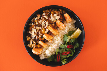 Asian cuisine. Shrimp with curry rice. Appetizing dish on an orange background