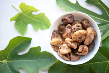 Top view of dried figs with leaves isolated on white wood background