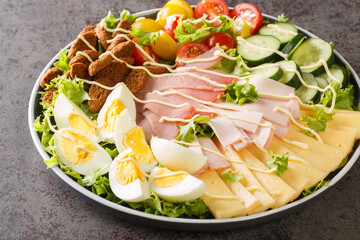 Delicious chef salad consisting of vegetables, lettuce, eggs, cheese and several types of meat...