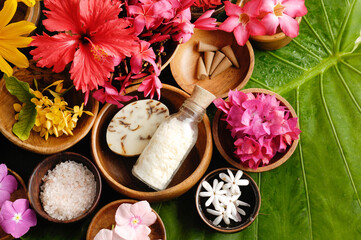 Spa setting with summer flower with salt ,soap in bowl on big leaf

