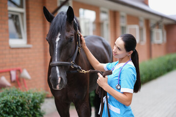 Female doctor in uniform with horse in stable - Powered by Adobe