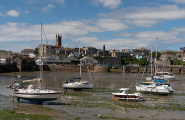 Fototapeta na wymiar Penzance, Cornwall, England, UK. 2022. Penzance Harbour with boats settled on the mud with a backdrop of the town centre. Cornwall UK.