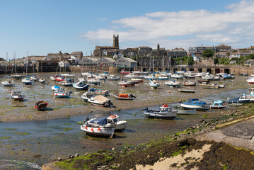 Penzance, Cornwall, England, UK. 2022. Penzance Harbour with boats settled on the mud with a...