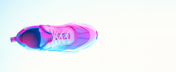 Aerial view of sports shoes, sneakers isolated over neoned background. Urban city fashion, fitness, sport, training concept.