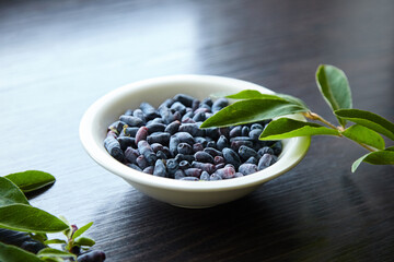 Honeysuckle berry or woodbine in plate over wooden table