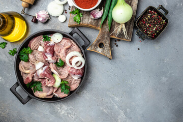 Raw chicken stomach, Traditional Korean spicy chicken gizzard with onions, garlic, chili and sesame on a gray background, place for text, top view