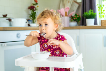 The child eats dumplings at the table. Selective focus.