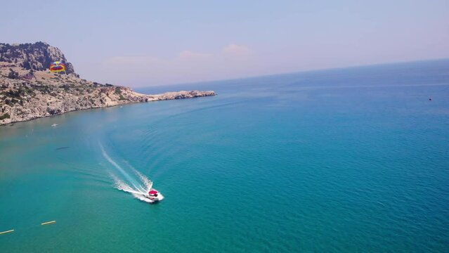 Tourists Parasailing In The Coast Of Tsambika Beach, Greece. - aerial