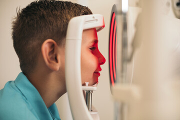 A child undergoes a corneal topographer to take information about the cornea. Optometry.