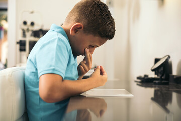 A child puts on a contact lens in an optician.