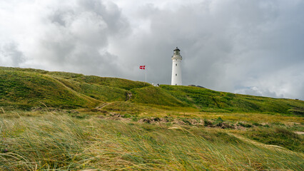 Fototapeta na wymiar White Lighthouse in the sand and grass dunes, Hirtshals Fyr in Hirtshals, North Jutland in Denmark, Europe