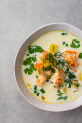 Norwegian salmon red fish soup with vegetables, herbs and cream, top view ,close up