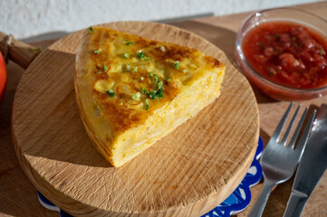 Spanish vegetarian food, portion of homemade potato omelette tortilla de patatas with onion served outdoor in morning sunlights