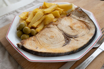 Seafood dish, grilled steak from swordfish or spada served with french fried potatoes and green olives