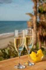 Outdoor breakfast with Spanish cava sparkling wine and pineapple with view on blue sea and sandy beach in Marbella, Costa del Sol vacation destination, Andalusia, Spain