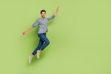 Fototapeta na wymiar Full length photo of cheerful handsome male go on walk enjoy summer vacation isolated on green color background
