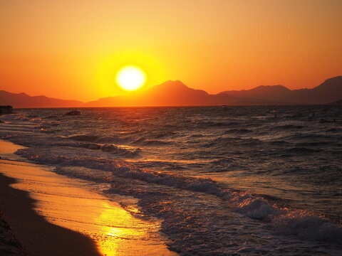 Sonnenuntergang am Strand und hinter Bergen