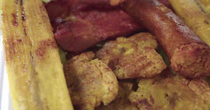 Plano detalle de comida de la selva peruana con cecina, patacones, pl&aacute;tano frito y chorizo ahumado.