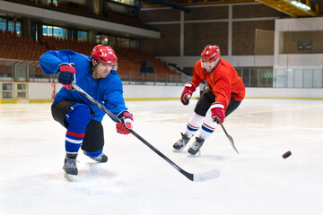 Ice hockey players playing ice hockey in the ice rink in winter