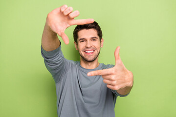 Photo of nice millennial brunet guy make photo wear grey pullover isolated on green color background