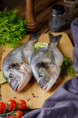 Raw peeled dorado fish with cooking ingredients. Fresh fish on a wooden background