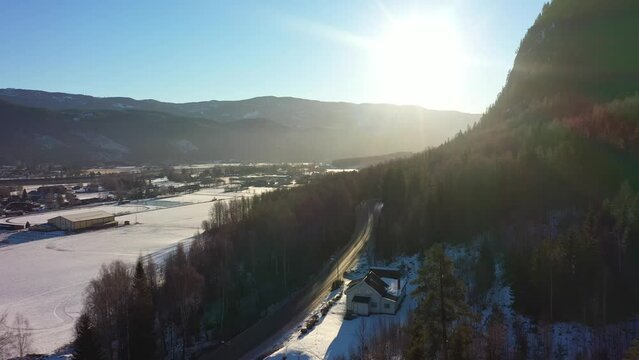 Sunrise above Hallingdal looking towards Moan and Beia in Nesbyen Norway - Forward moving aerial above lush forest with farmland in background valley