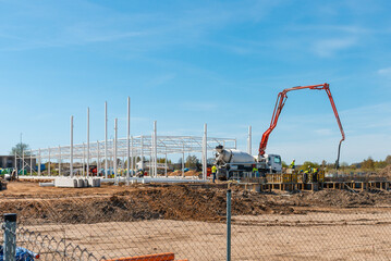 Urban area with machinery, car cement mixer,people are working on construction site.