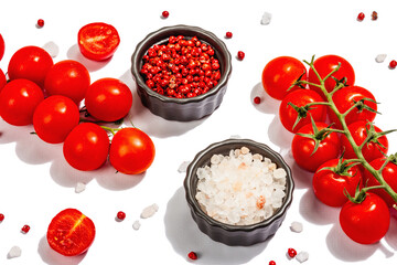 Cooking background with tomato cherry, sea salt, and rose peppercorn isolated on white background