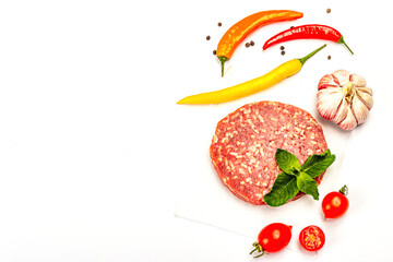 Raw steak cutlets from minced beef meat isolated on white background. Fresh vegetables, basil