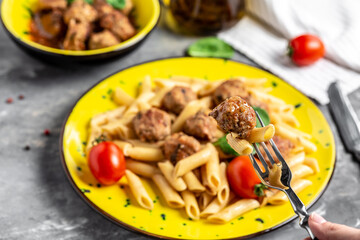 penne pasta with meatballs and spicy tomato sauce on a gray background. Restaurant menu, dieting, cookbook recipe banner, place for text, top view
