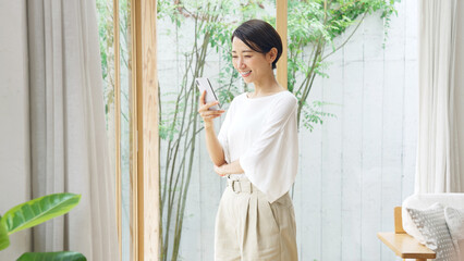 笑顔でスマホを見るミドル女性