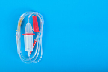Intravenous drip system on a blue background with space for text.