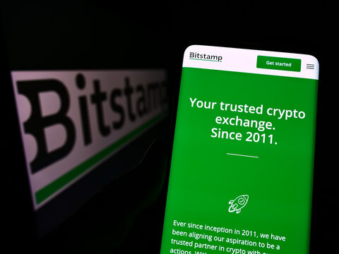 Stuttgart, Germany - 07-23-2022: Person holding cellphone with webpage of cryptocurrency exchange company Bitstamp Ltd. on screen with logo. Focus on center of phone display.