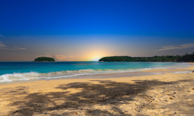 Obraz premium Colourful Skies Sunset over Kata Beach in Phuket Thailand. This Lovely island waters are turquoise blue waters, lush green mountains colourful skies and beautiful views of Pa Tong Patong