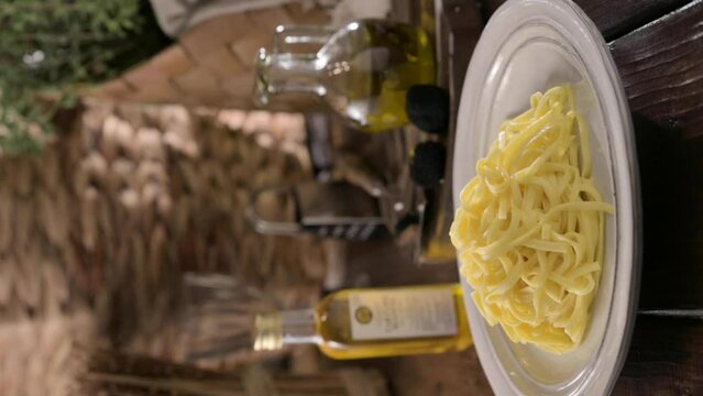 Fragrant black truffle, truffle oil and tagliatelle pasta. Steam over a dish of food. Expensive lunch, homemade pasta, traditional in the Lazo region of Italy. 4k footage. Vertical for social networks