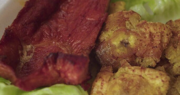 Plano detalle de plano peruano de la selva con patacones o tostones, lechuga y cecina.