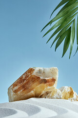 Stone podium on a blue background with palm leaves and white sand. Nature, sand, palm tree, stone....