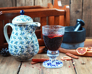 Mulled wine in a beautiful glass with a ceramic stem and a jug. Selective focus.