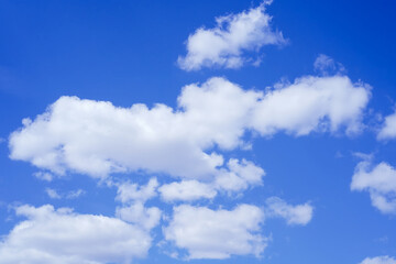 Several white clouds of various shapes in a bright blue sky