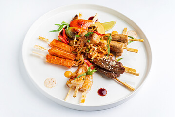 meat and fish kebabs on white plate