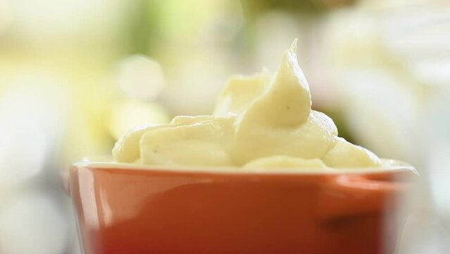 The cook serves mashed potato into a bowl.
