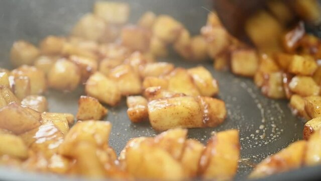 Cooking of pieces apples with butter, brown sugar and cinnamon.
