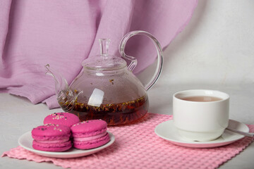 breakfast of herbal tea with lavender and sweet colorful dessert macarons on white background