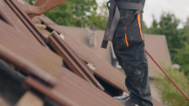 Roofer placing roof tiles on top to prepare solar panel installation, side view