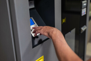 White Caucasian men hand paid a parking ticket at a parking machine. There are no recognizable...