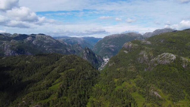 Flight over the mountains. The nature of Norway goths and the village at the bottom of the valley near the river and fjord
