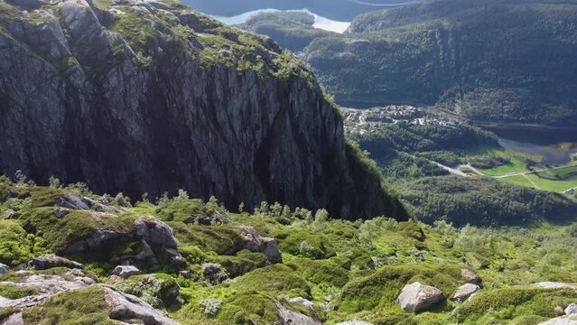 Flight over the mountains. The nature of Norway goths and the village at the bottom of the valley near the river and fjord