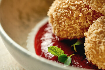 Croquette with cheese in cranberry sauce. Close-up selective focus